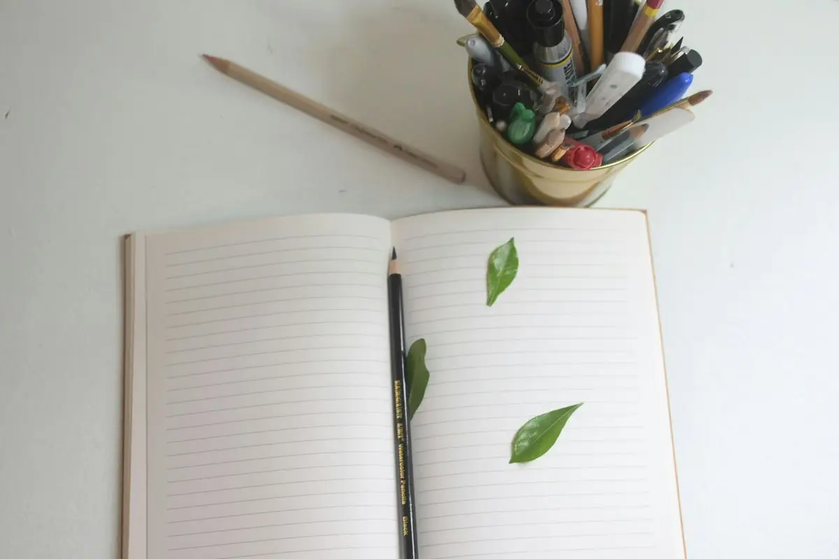 Open notebook with pencils and markers