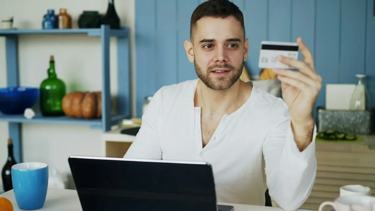 Man holding a credit card while shopping on a laptop