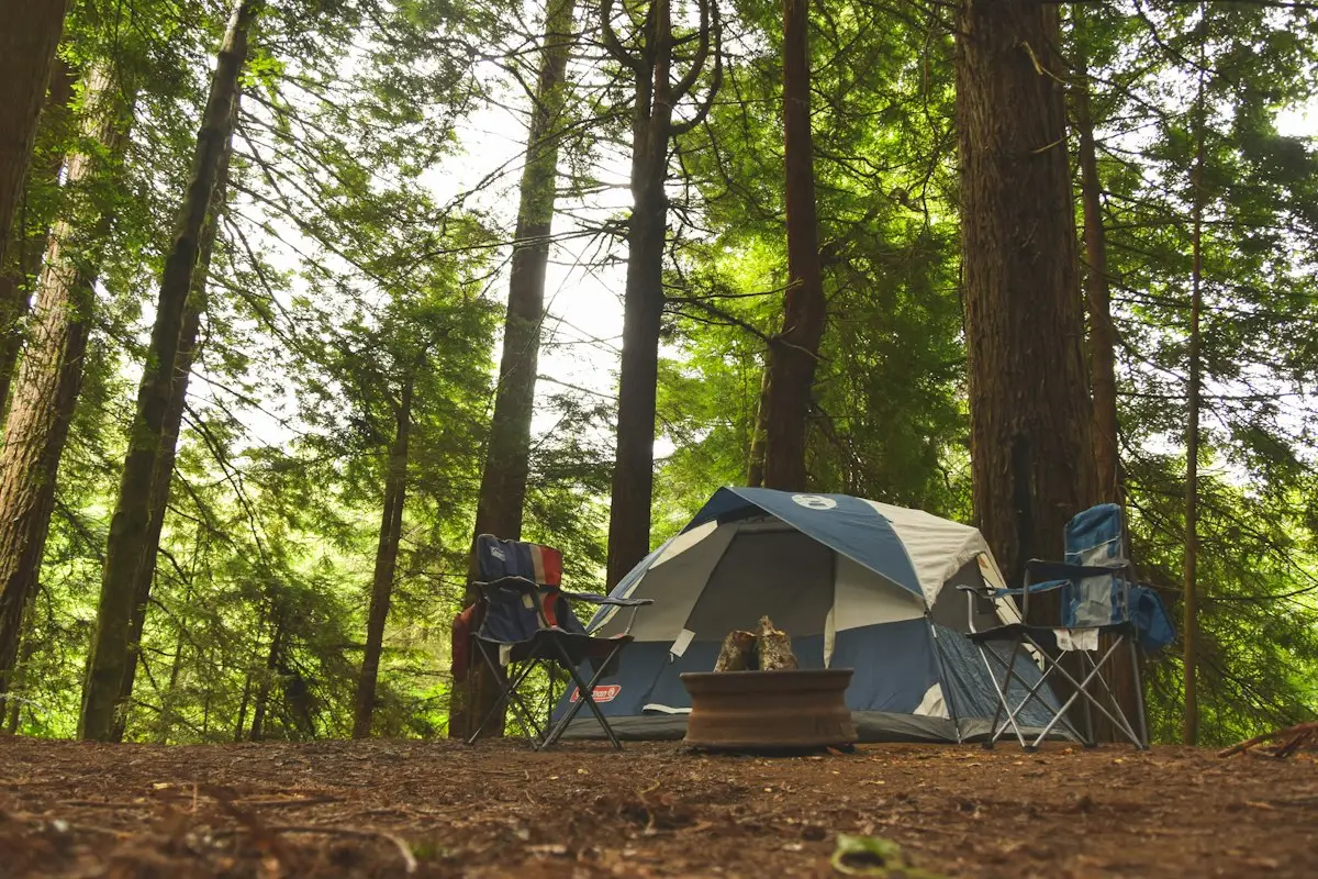 Two blue camping chairs beside a tent