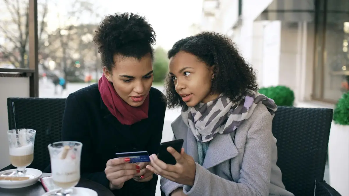 Two women checking a smartphone with a card in hand
